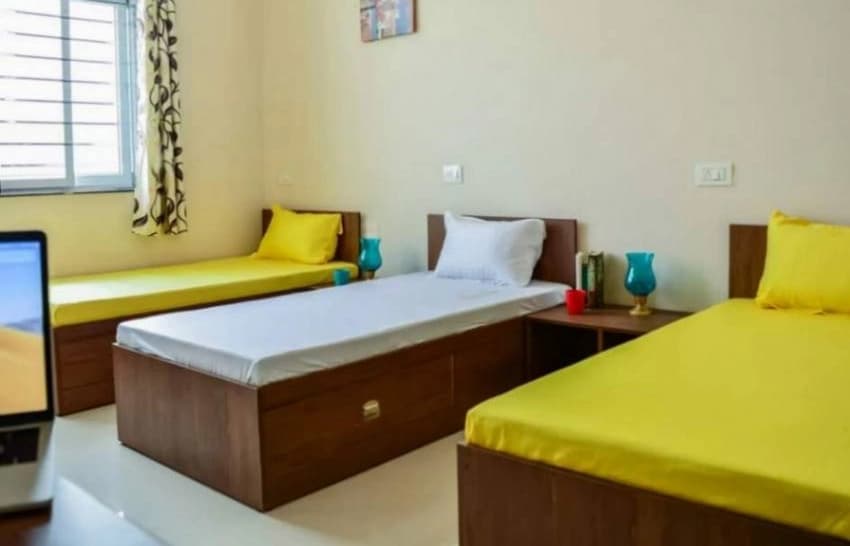 Clean student accommodation room with comfortable bedding in Goa